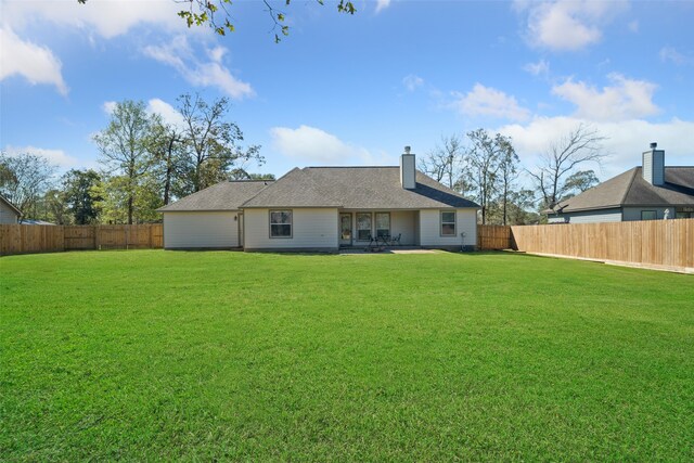 rear view of house featuring a lawn and a patio area