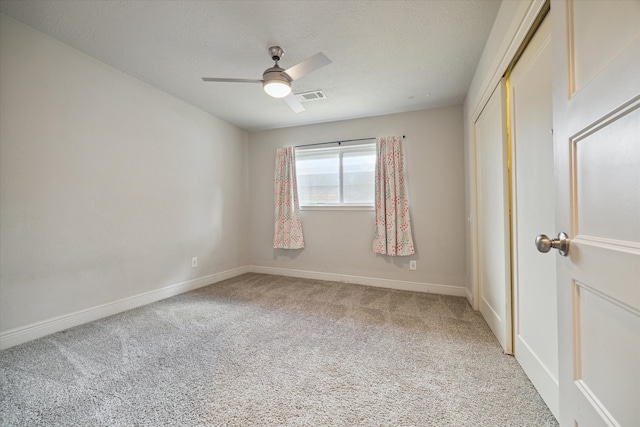 carpeted empty room featuring ceiling fan