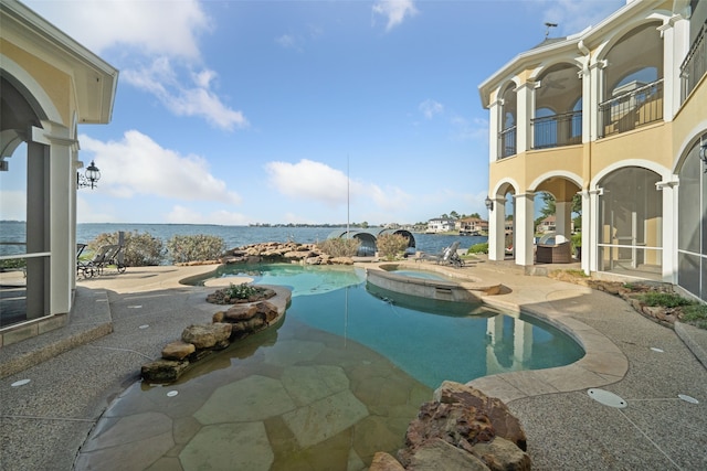 view of swimming pool featuring an in ground hot tub, a patio, and a water view