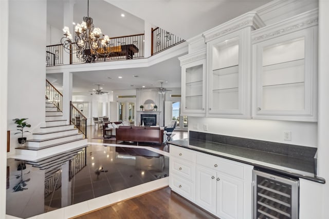 kitchen featuring dark wood-type flooring, a notable chandelier, white cabinets, wine cooler, and hanging light fixtures