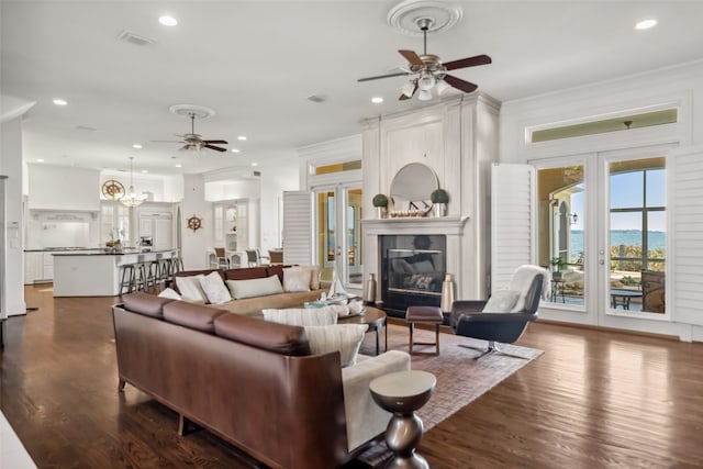 living room with ceiling fan, crown molding, dark wood-type flooring, and french doors