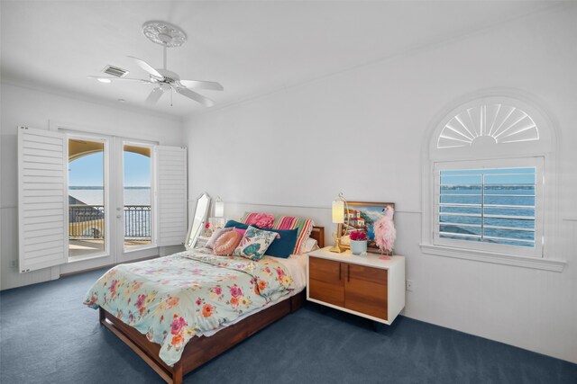 carpeted bedroom featuring access to outside, ceiling fan, and a water view