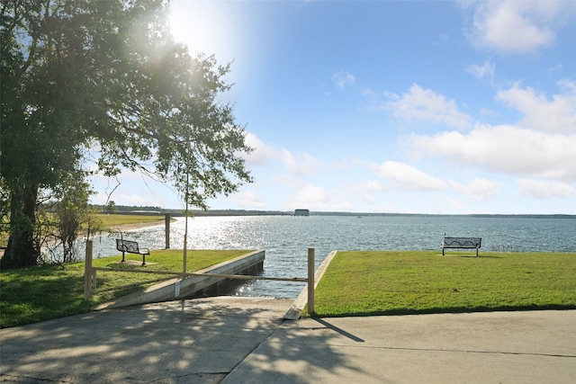 dock area featuring a lawn and a water view