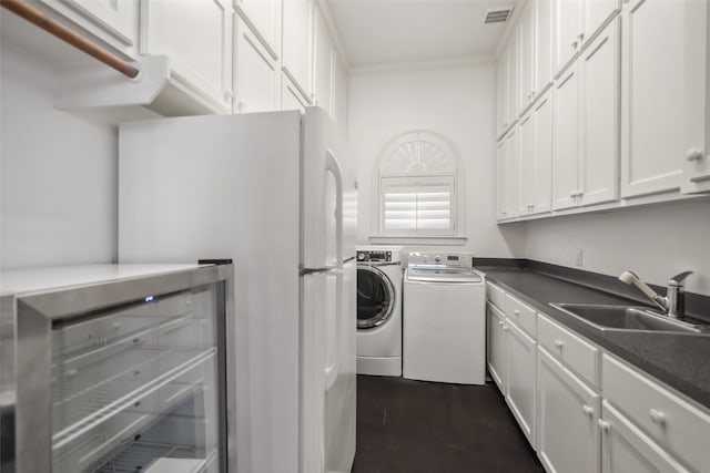 laundry area with dark hardwood / wood-style floors, separate washer and dryer, and sink