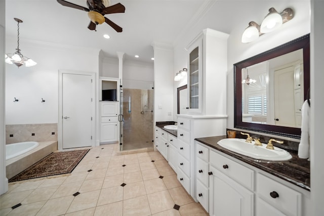 bathroom with tile patterned flooring, shower with separate bathtub, vanity, ceiling fan with notable chandelier, and ornamental molding