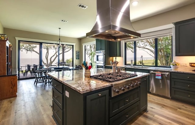 kitchen featuring a center island, light hardwood / wood-style flooring, light stone countertops, island exhaust hood, and stainless steel appliances