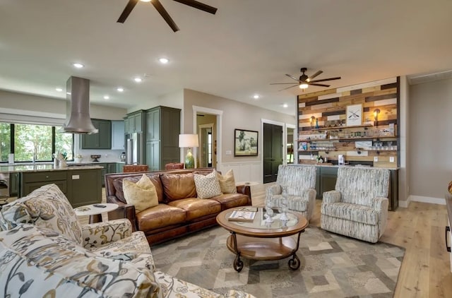 living room with ceiling fan and light hardwood / wood-style flooring