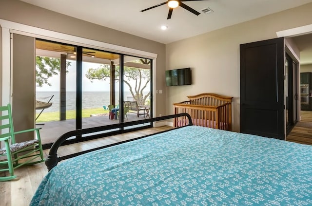 bedroom with hardwood / wood-style flooring, ceiling fan, access to outside, and multiple windows