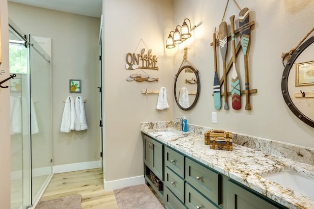 bathroom featuring vanity, an enclosed shower, and hardwood / wood-style flooring