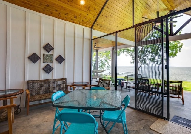 dining space with concrete floors, a water view, and wood ceiling