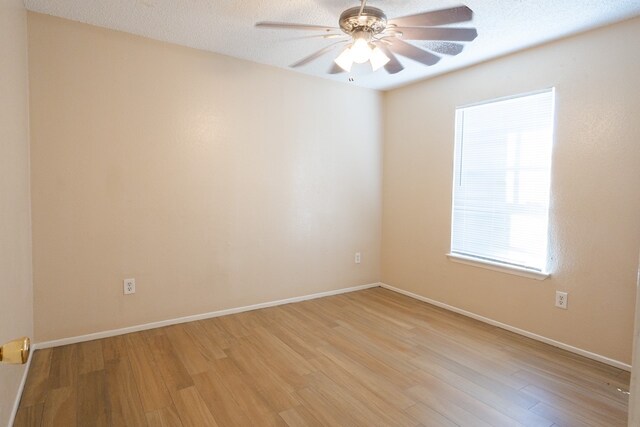 empty room featuring a textured ceiling, light hardwood / wood-style flooring, and ceiling fan