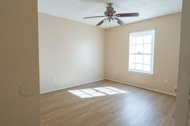 empty room featuring ceiling fan, light hardwood / wood-style floors, and a textured ceiling