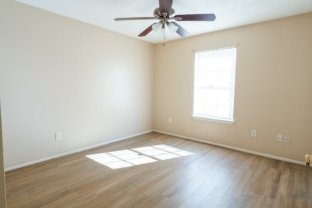 empty room featuring a textured ceiling, light hardwood / wood-style flooring, and ceiling fan