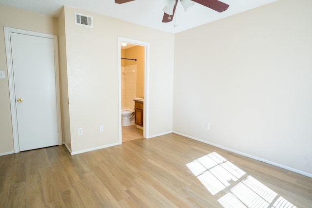 unfurnished bedroom featuring ceiling fan, a closet, connected bathroom, and light hardwood / wood-style flooring