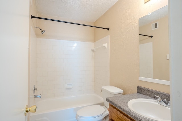 full bathroom featuring tiled shower / bath, vanity, a textured ceiling, and toilet