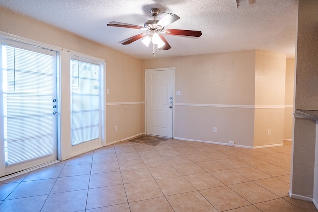 unfurnished room featuring light tile patterned floors, a textured ceiling, and ceiling fan