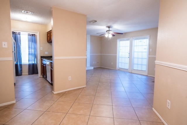 kitchen featuring dishwasher, light tile patterned floors, a textured ceiling, and ceiling fan