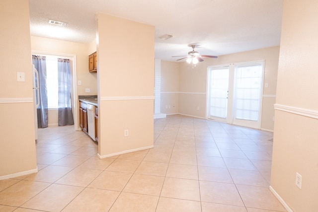 kitchen featuring light tile patterned floors, a textured ceiling, white dishwasher, and ceiling fan