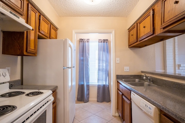 kitchen with a textured ceiling, white appliances, light tile patterned floors, and sink