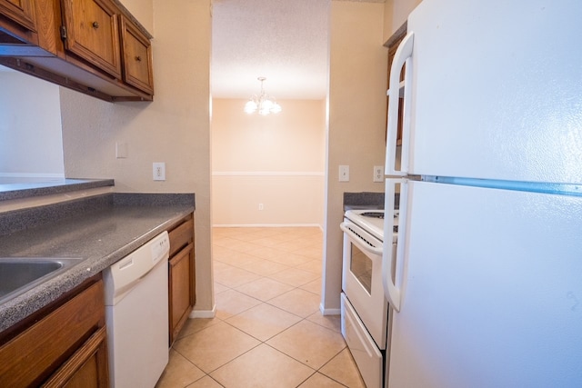 kitchen with light tile patterned flooring, decorative light fixtures, white appliances, and a notable chandelier