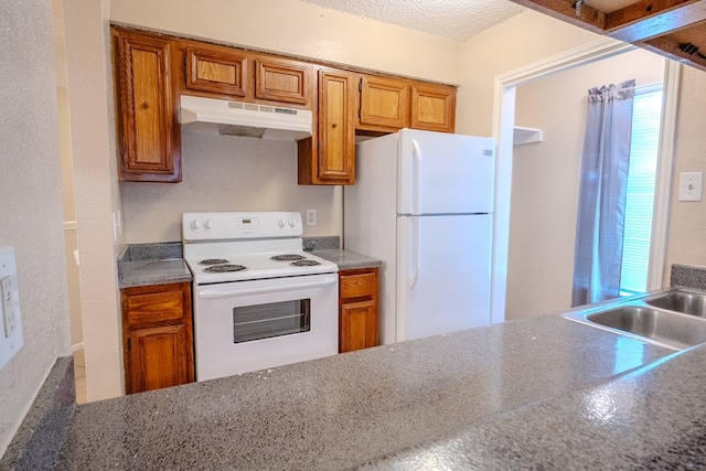 kitchen featuring a textured ceiling, sink, and white appliances