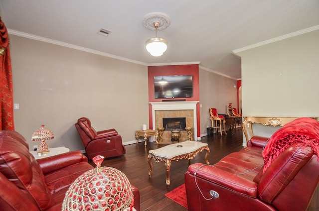 living room featuring a tile fireplace, crown molding, and dark hardwood / wood-style flooring