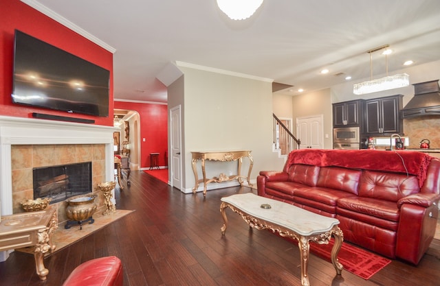 living room with dark hardwood / wood-style flooring, ornamental molding, and a fireplace