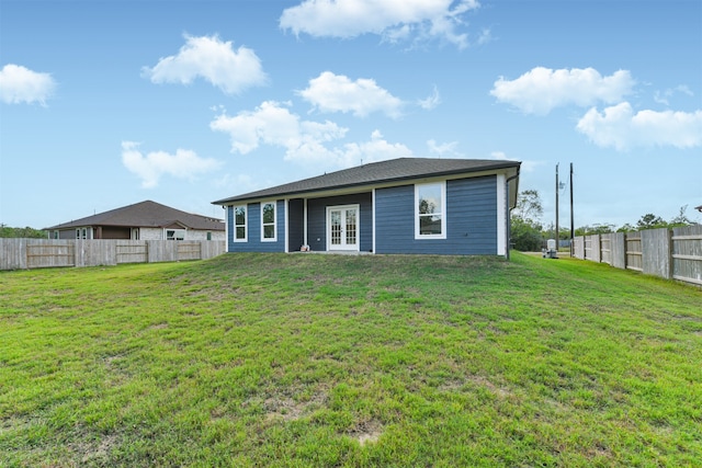 back of property with a lawn and french doors