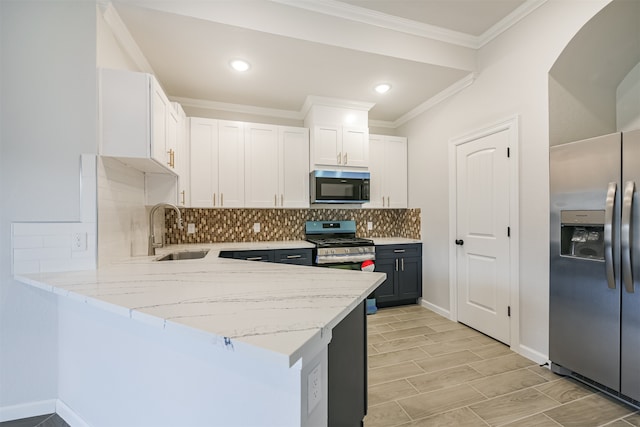 kitchen with white cabinets, sink, light stone counters, kitchen peninsula, and stainless steel appliances