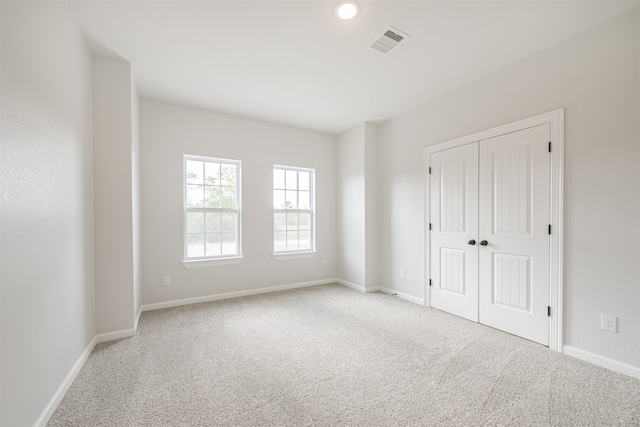 unfurnished room featuring light colored carpet