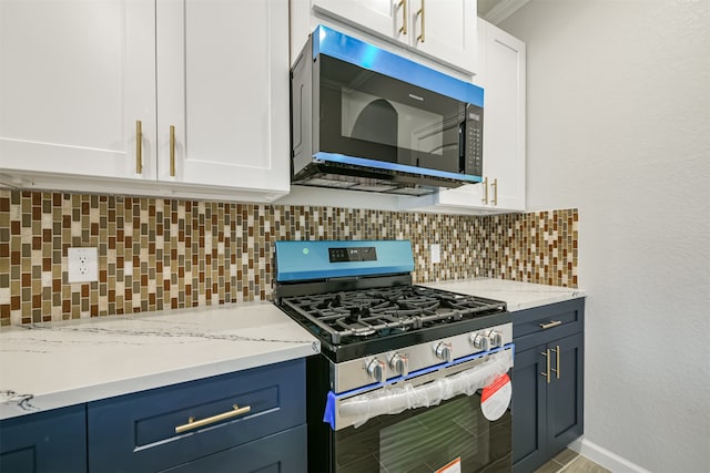 kitchen with backsplash, white cabinetry, and appliances with stainless steel finishes