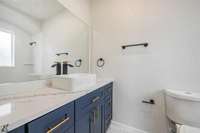 bathroom featuring a shower, vanity, and toilet