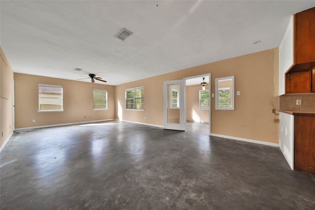 unfurnished living room featuring ceiling fan and plenty of natural light