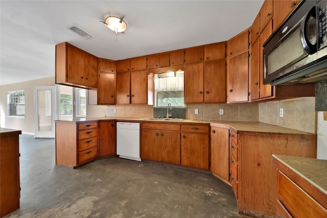 kitchen featuring dishwasher, decorative backsplash, and sink