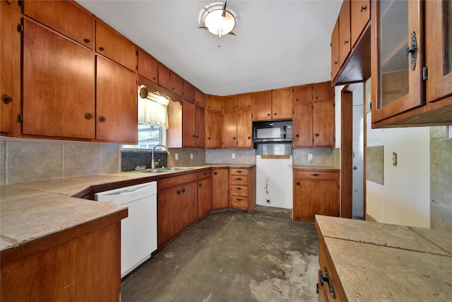 kitchen featuring tasteful backsplash, sink, and white dishwasher