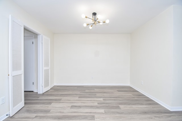 unfurnished dining area featuring a notable chandelier and light hardwood / wood-style flooring