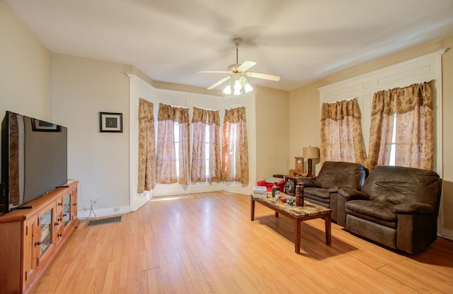 living room with light wood-type flooring and ceiling fan