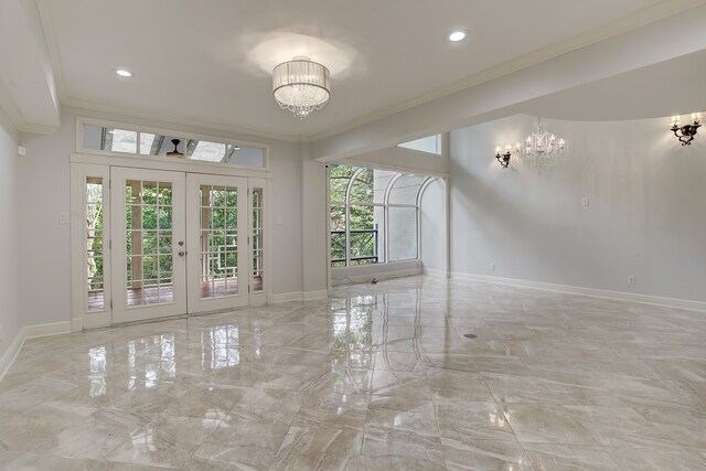 empty room with french doors, ornamental molding, and a chandelier