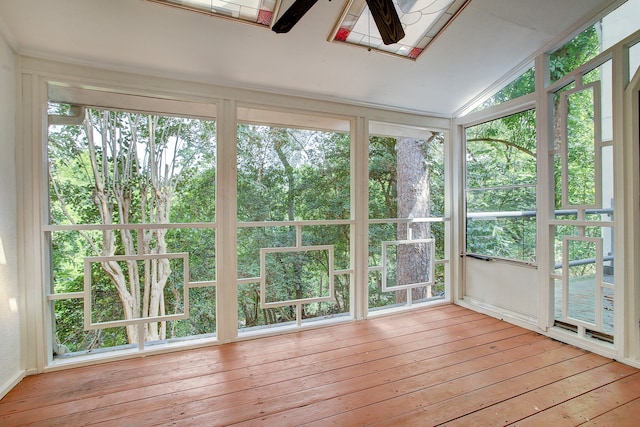 unfurnished sunroom with lofted ceiling with skylight and ceiling fan