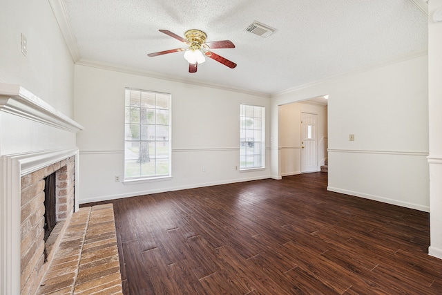 unfurnished living room with crown molding, dark hardwood / wood-style flooring, a textured ceiling, and a brick fireplace