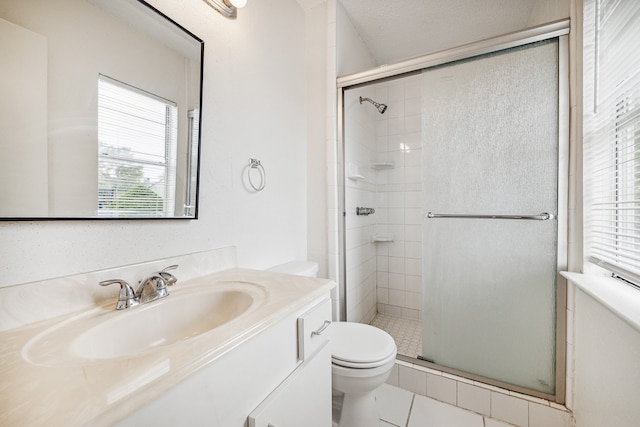 bathroom with tile patterned floors, a healthy amount of sunlight, toilet, and a shower with shower door