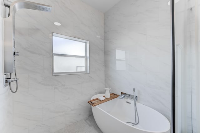 bathroom with a bathtub and tile walls