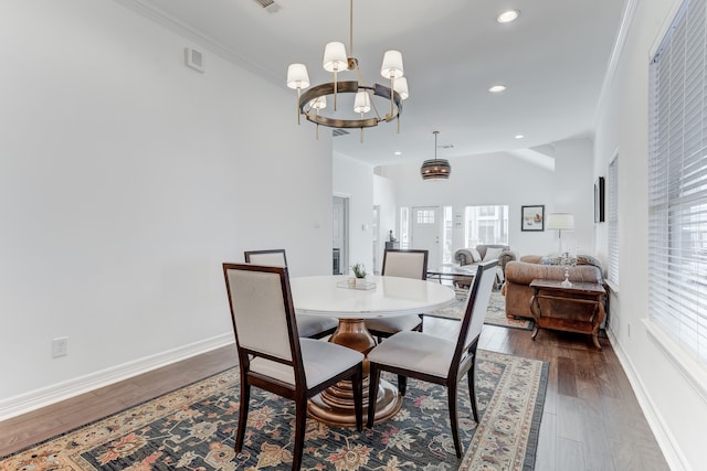 dining space featuring crown molding, dark wood-type flooring, and a notable chandelier