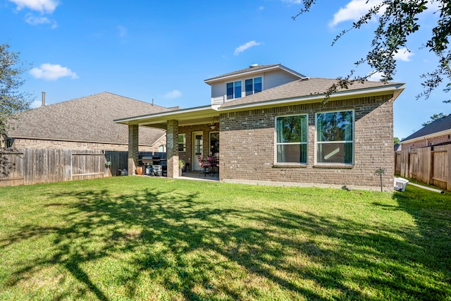 rear view of house featuring a yard and a patio area