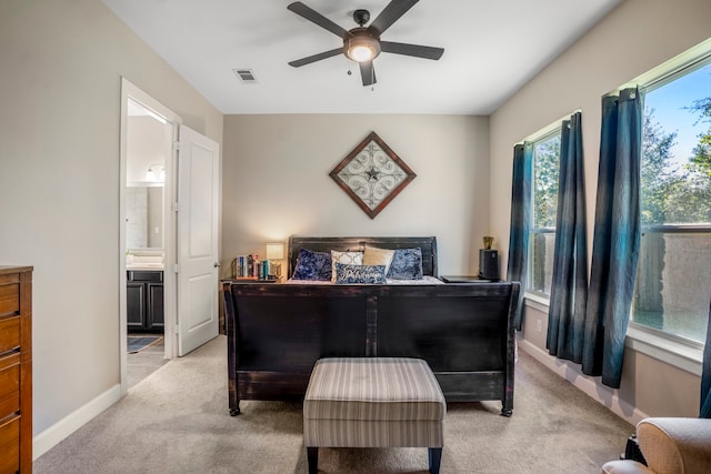 bedroom featuring ceiling fan, light carpet, and ensuite bath