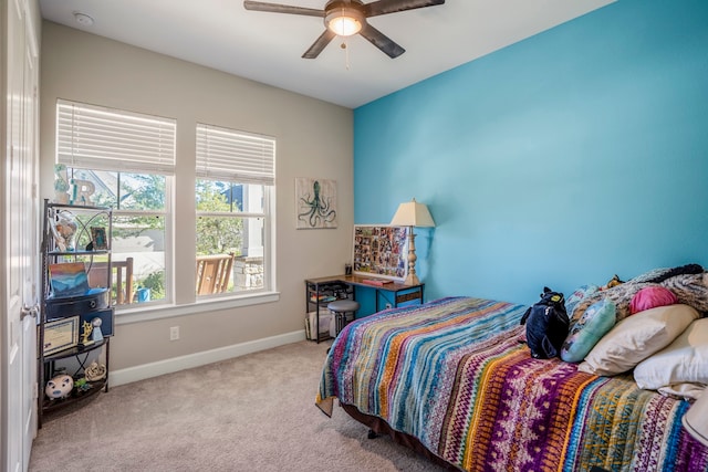 bedroom featuring ceiling fan, multiple windows, and light carpet