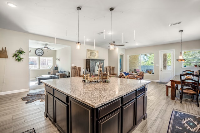 kitchen featuring decorative light fixtures, plenty of natural light, and light stone counters