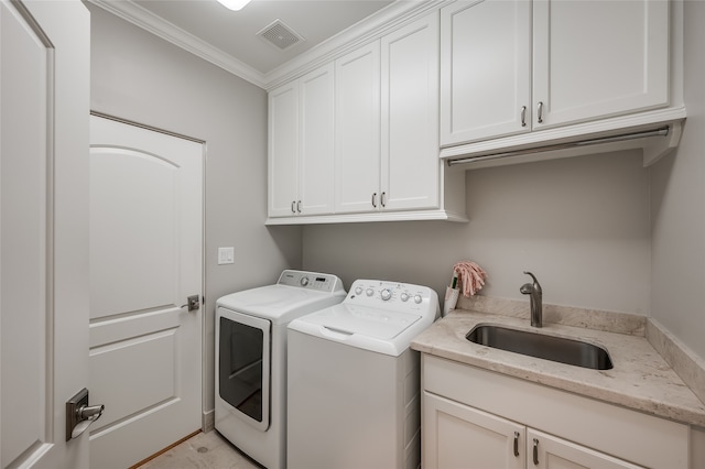 washroom with crown molding, washer and clothes dryer, cabinets, and sink