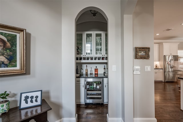 bar featuring white cabinets, stainless steel fridge, dark hardwood / wood-style flooring, and wine cooler