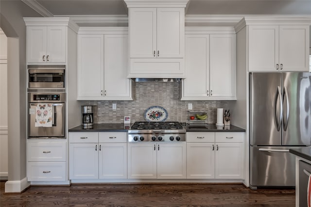 kitchen with decorative backsplash, dark hardwood / wood-style flooring, ornamental molding, stainless steel appliances, and white cabinetry